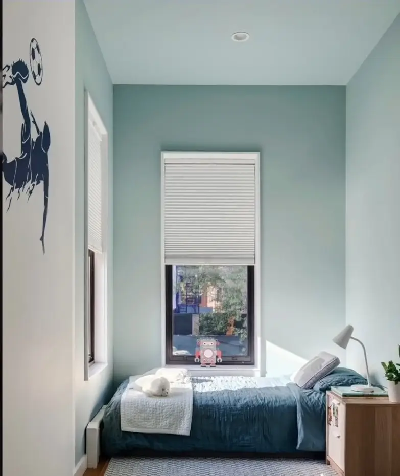 seafoam blue bedroom with a large window