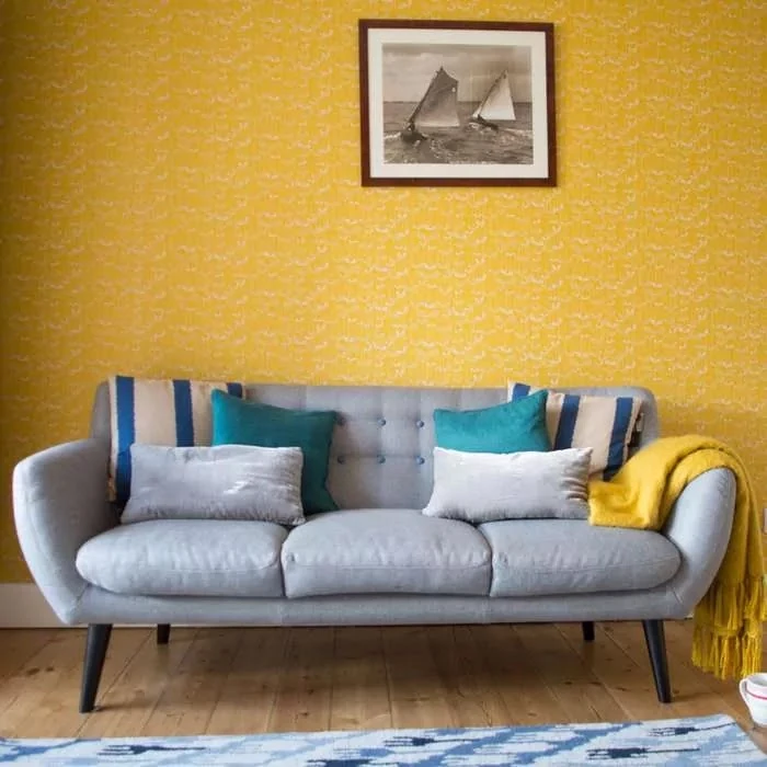 yellow living room wall with grey sofa