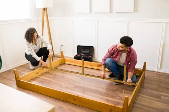 A man and woman disassembling the bed