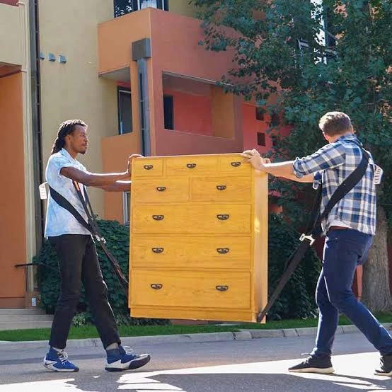 Two men moving dresser with dolly